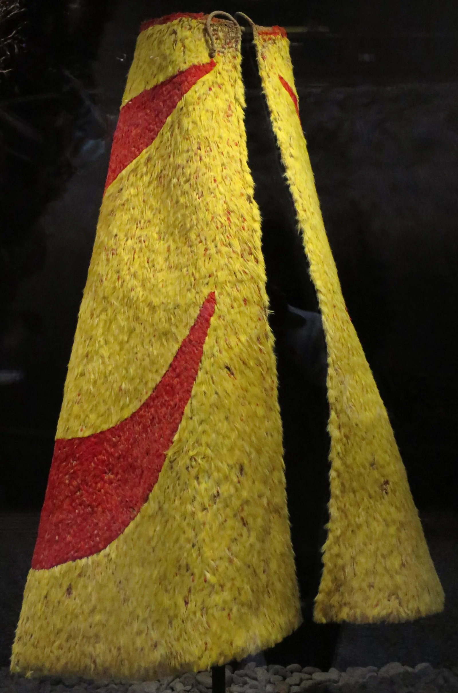 A red and yellow Hawaiian feather cloak displayed at the Bishop Museum