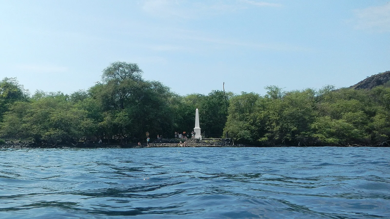 The white Captain Cook Monument obelisk seen across the water of Kealakekua Bay