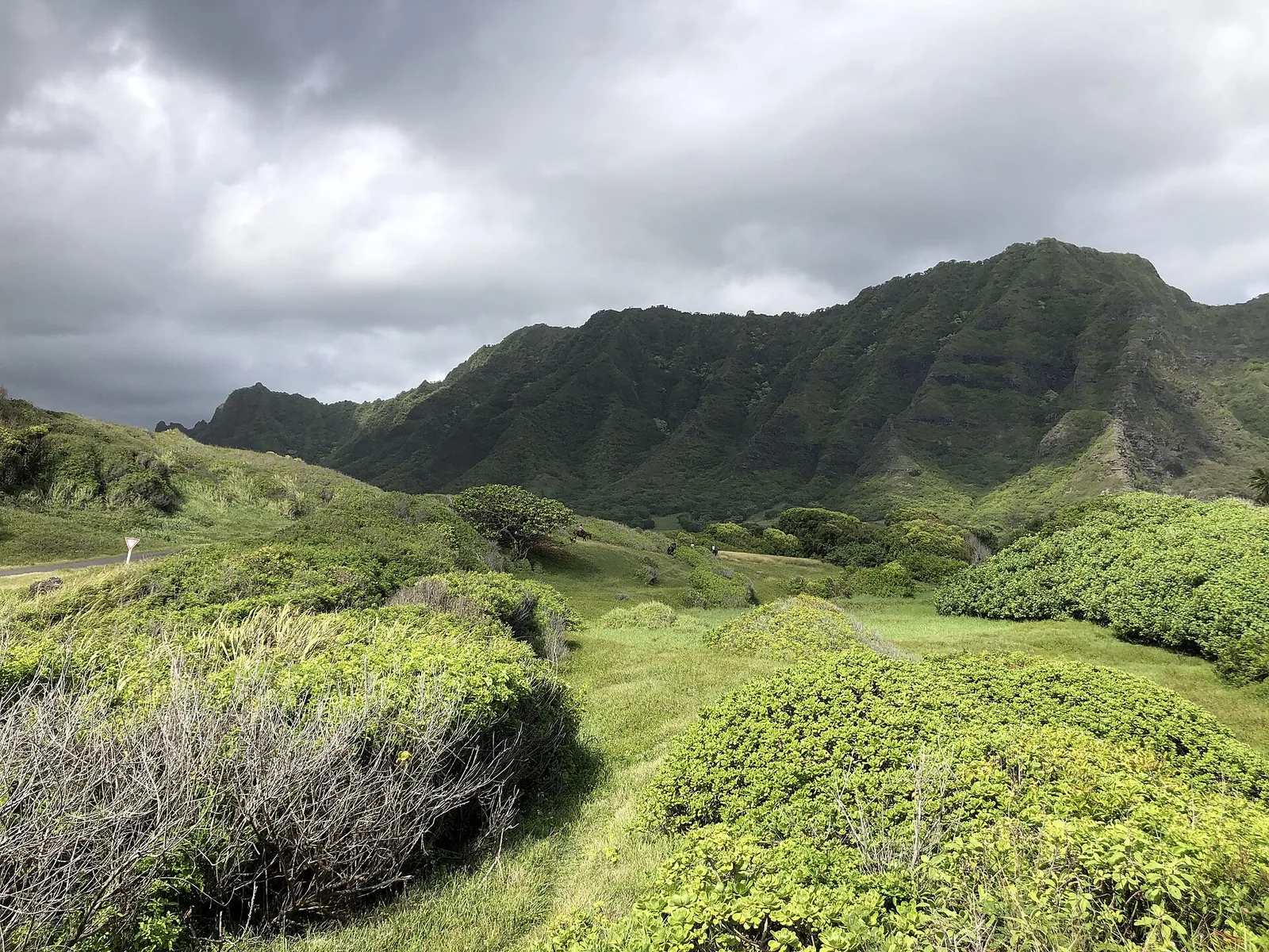 Kaaawa Valley at Kualoa Ranch with green ridges under cloud on Oahu's windward coast