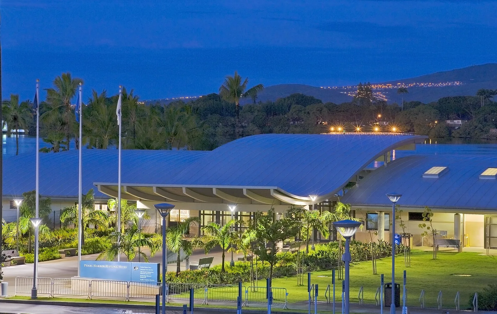 The Pearl Harbor Visitor Center buildings and lawns lit up at dusk