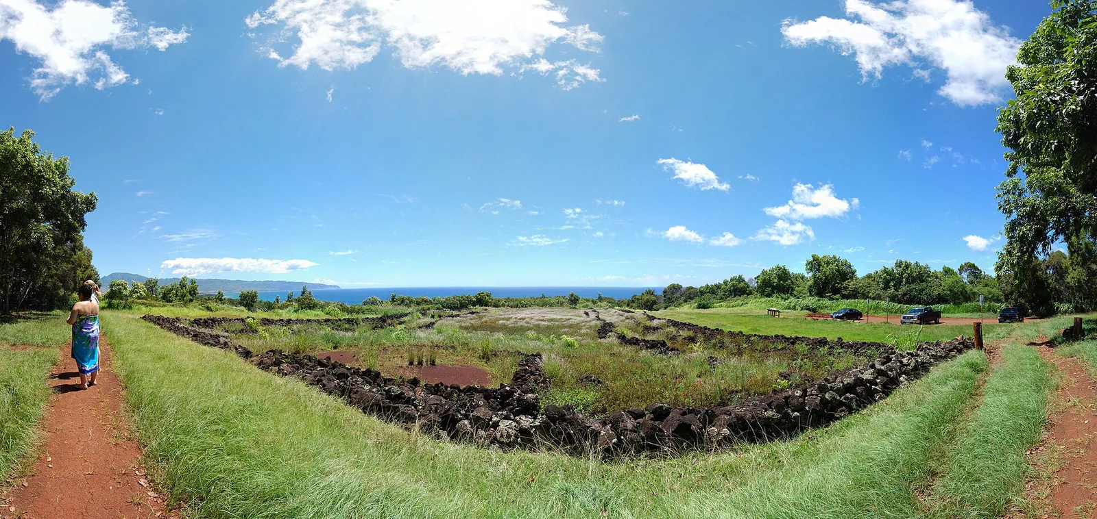 The low stone walls of Puu o Mahuka Heiau on a grassy bluff above the North Shore