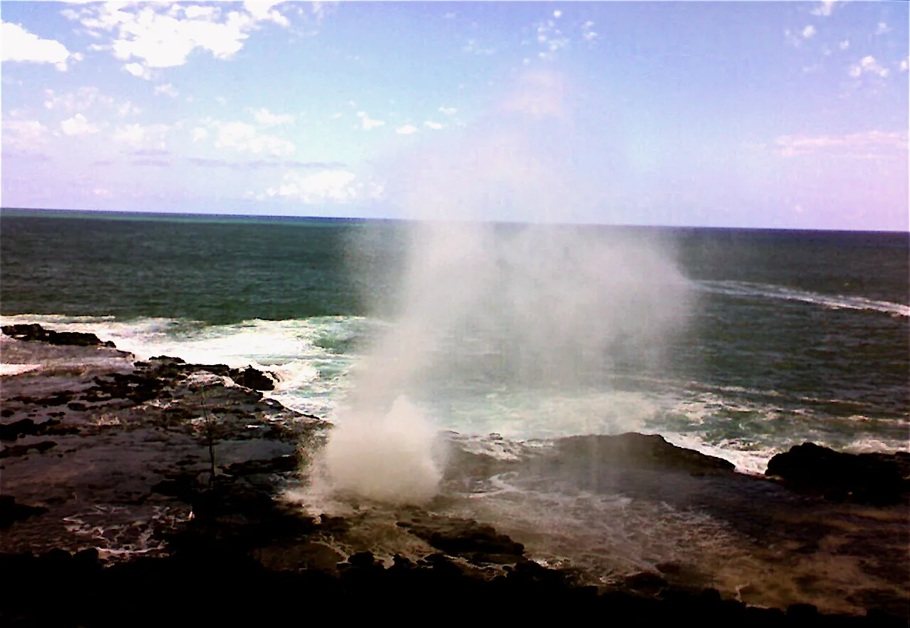 A plume of seawater spraying from Spouting Horn lava tube on the Poipu coast