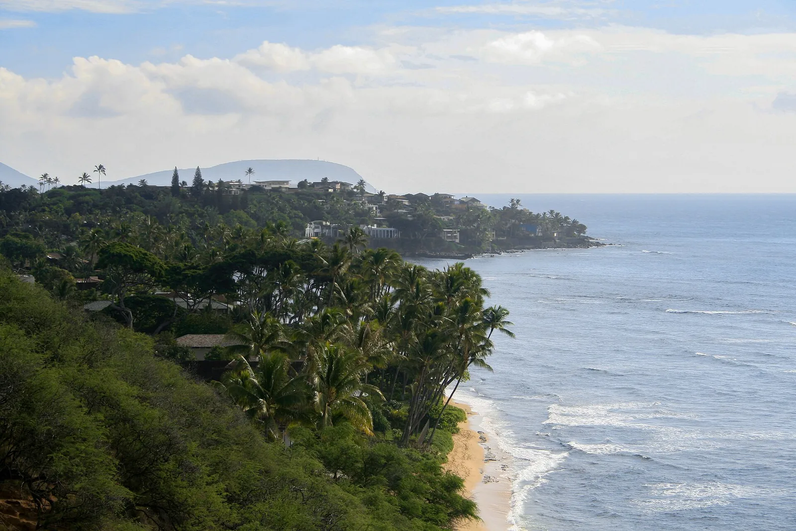 The North Shore coastline at Sunset Beach, with palms, houses and surf along the sand
