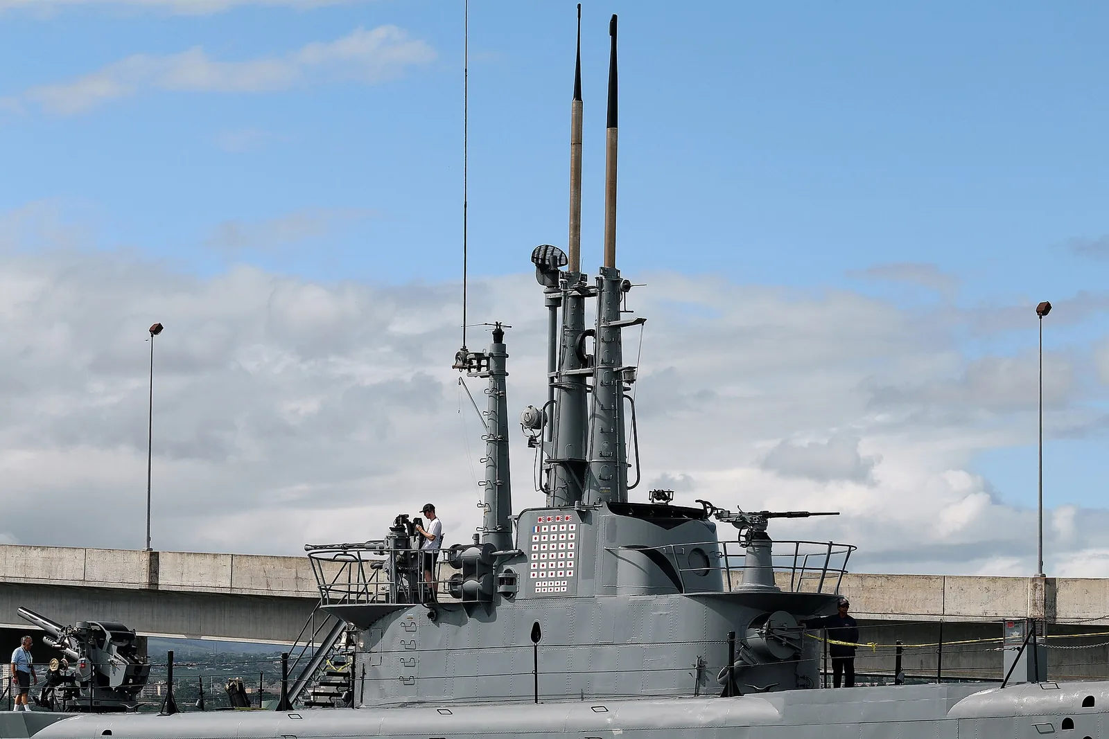 The conning tower and deck gun of the submarine USS Bowfin under a blue sky