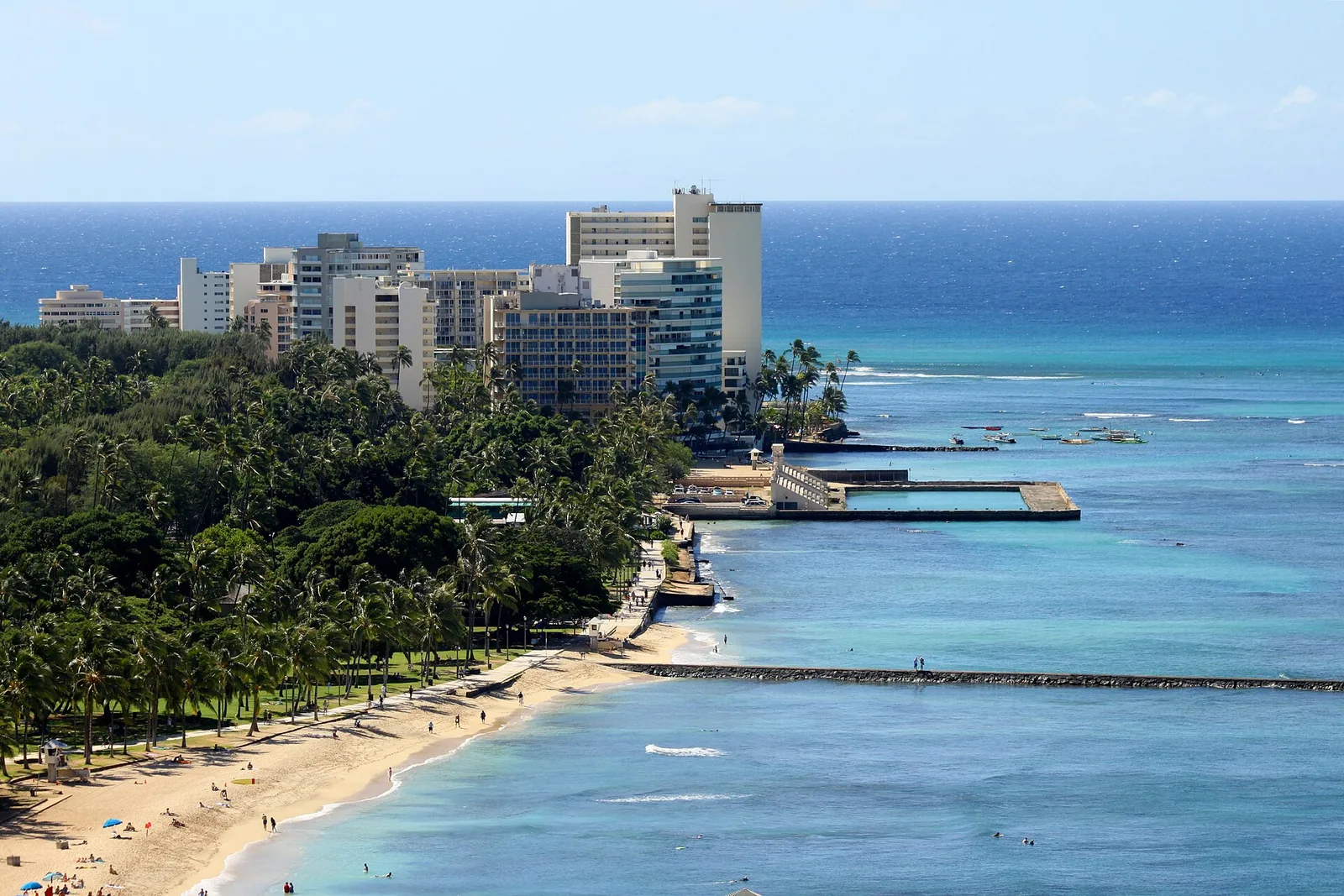 Aerial view of the Waikiki shoreline with concrete groins and breakwaters jutting into turquoise water