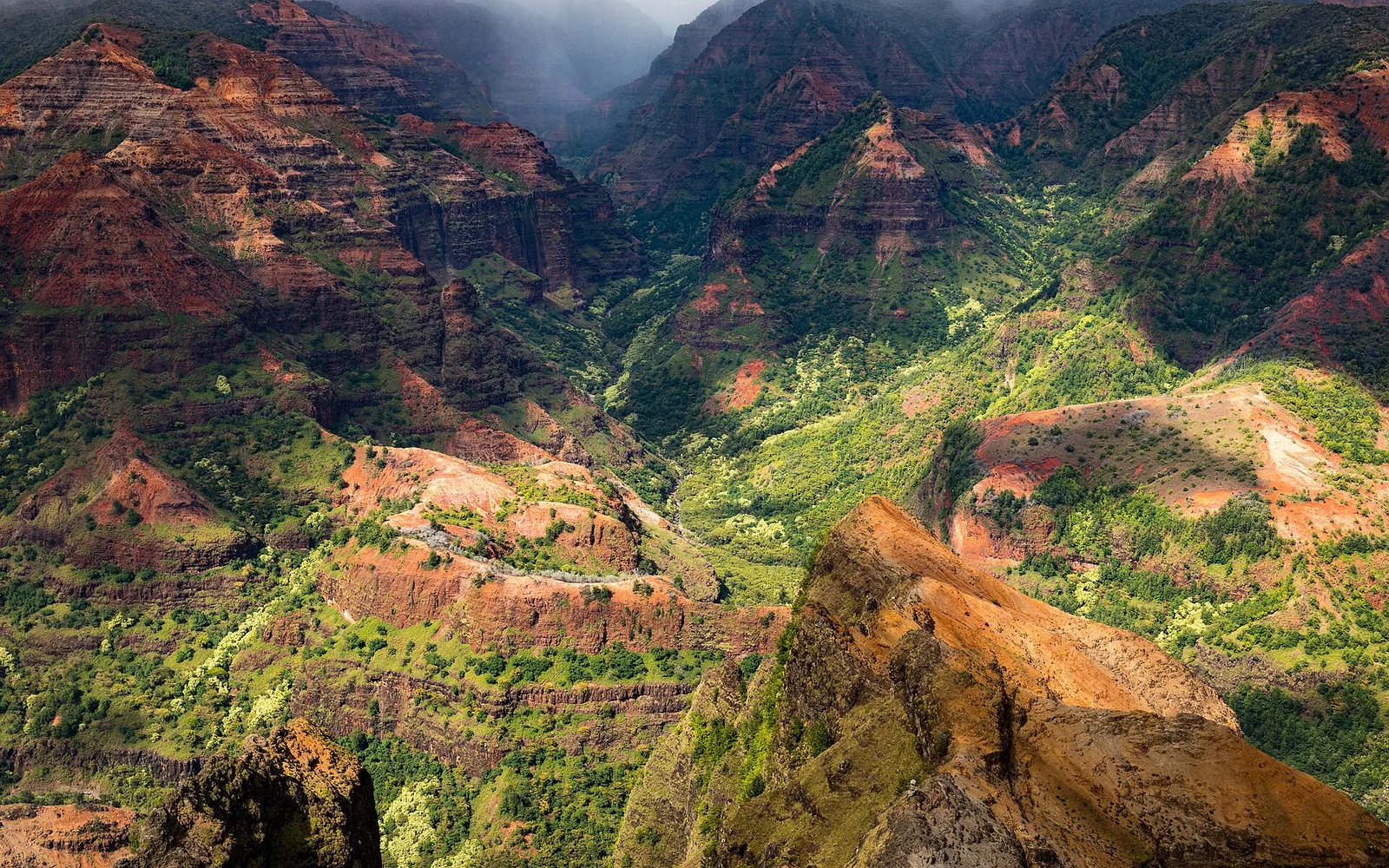 Red and green ridges of Waimea Canyon on Kauai under low cloud