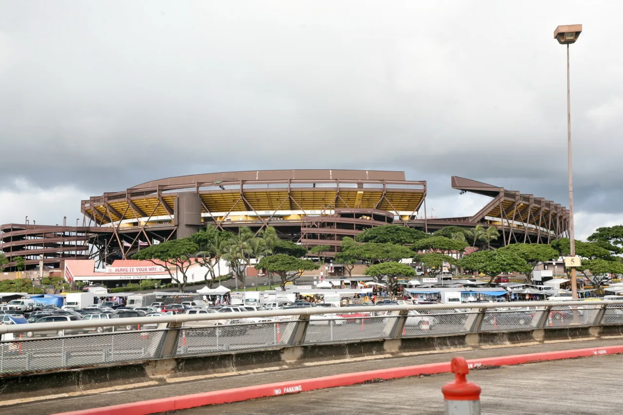 Vendor tents and shoppers at the Aloha Stadium Swap Meet with the stadium behind