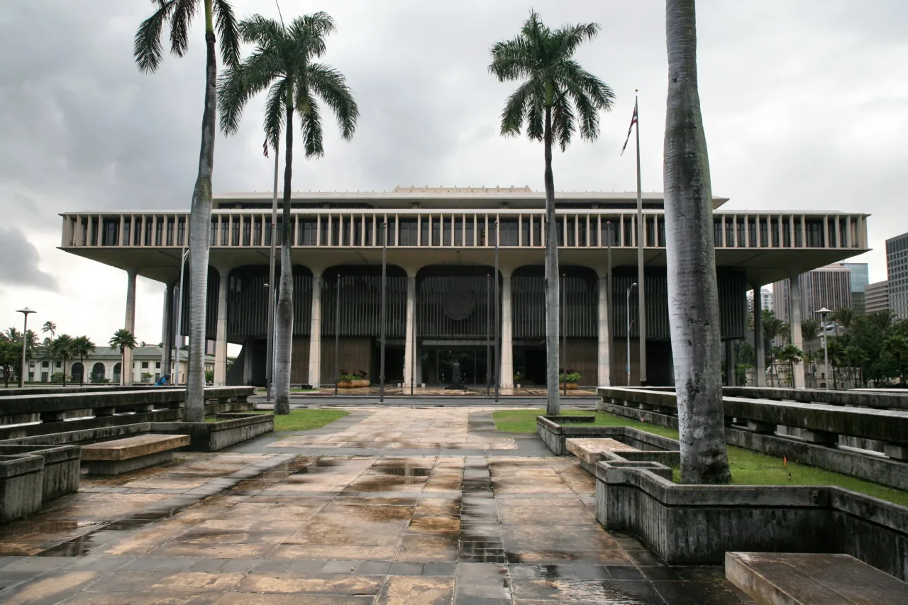 The open-sided Hawaii State Capitol in Honolulu framed by royal palms