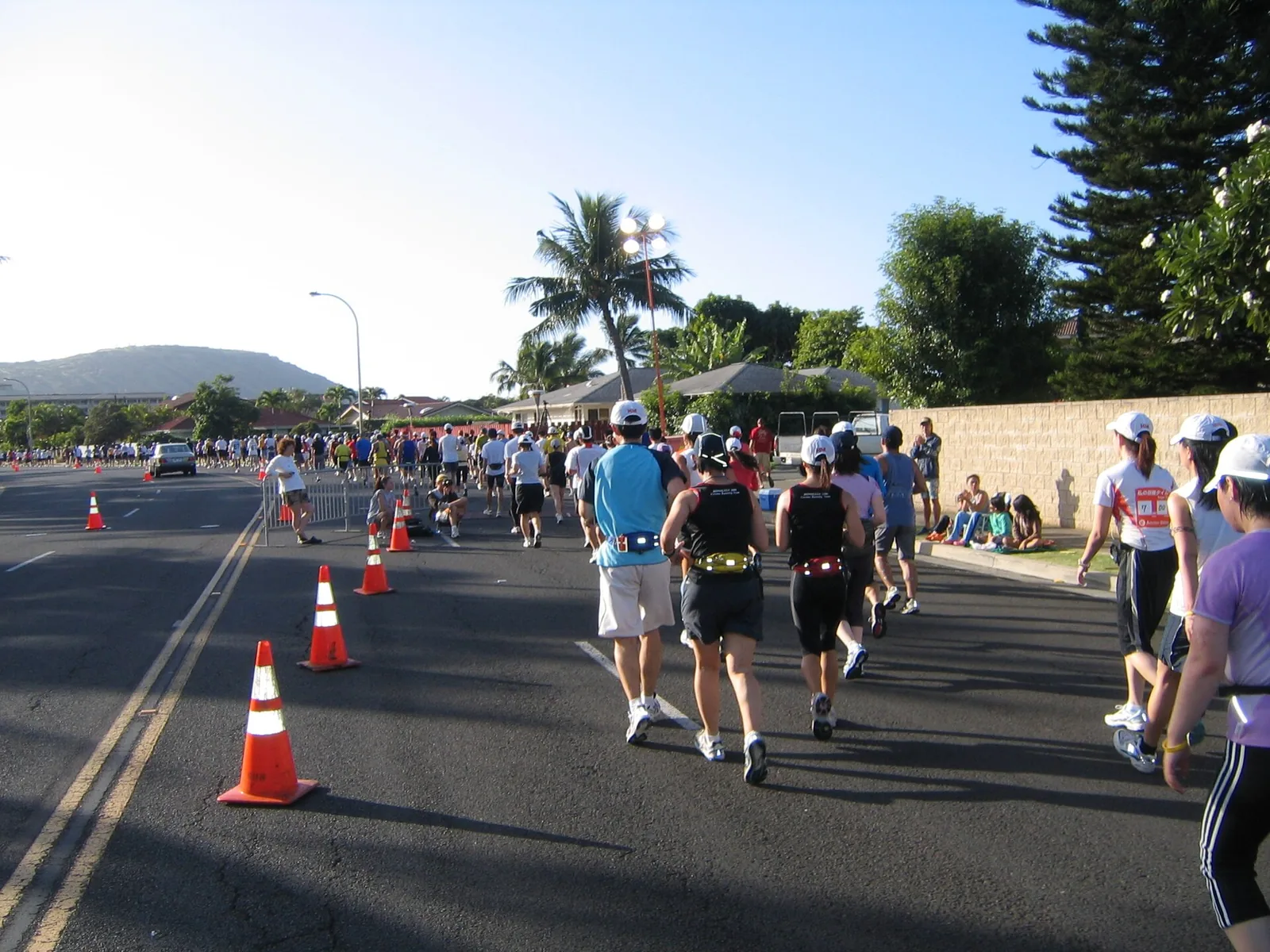 Runners on a sunny highway in east Honolulu during the Honolulu Marathon, with Koko Head behind