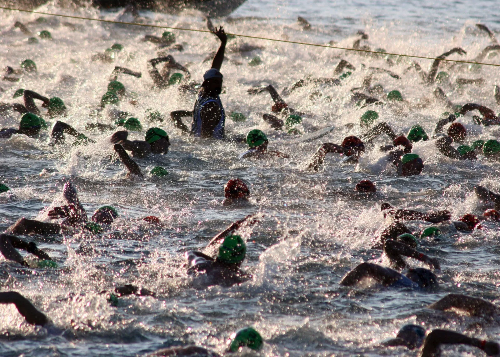Hundreds of triathletes churning the water at the swim start of the Ironman World Championship in Kailua Bay