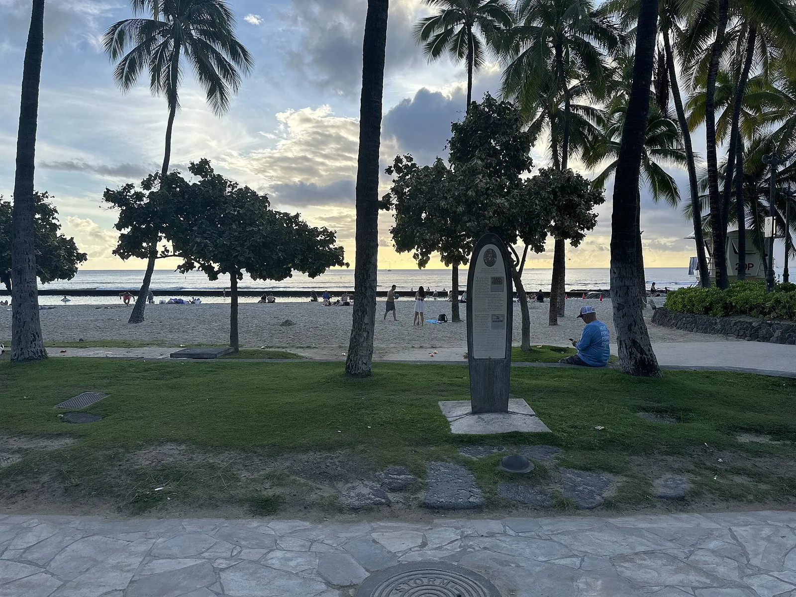 Palm-shaded lawn and sand at Kuhio Beach Park in Waikiki, the easiest first swim for Hawaii with kids