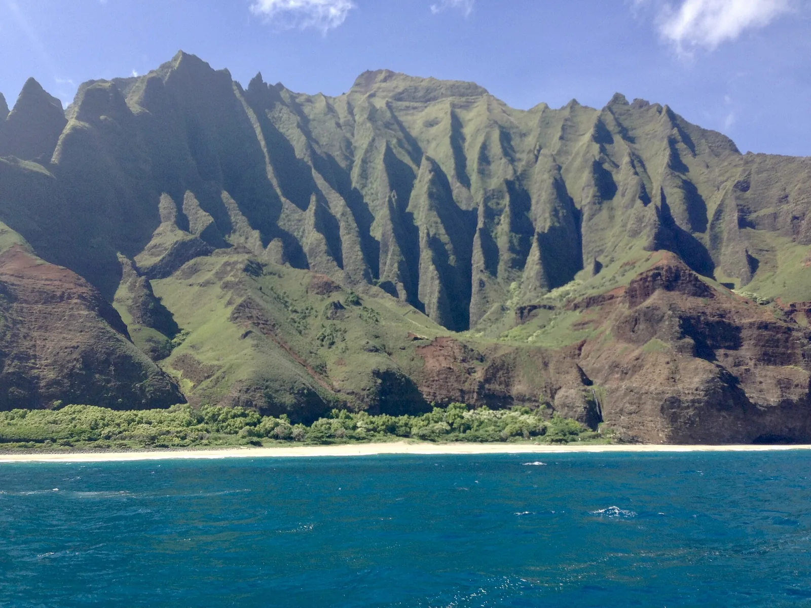 The fluted green cliffs of the Napali Coast on Kauai seen from a boat
