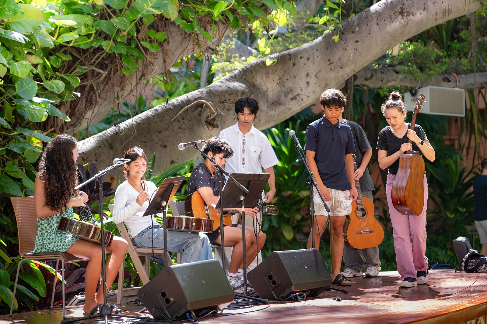 Young musicians playing guitar and ukulele on a garden stage at the Royal Hawaiian Center, free entertainment while shopping in Honolulu